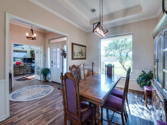 dining space featuring a tray ceiling, crown molding, dark hardwood / wood-style floors, and a notable chandelier