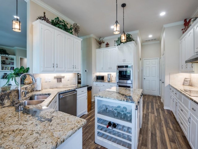 kitchen with white cabinets, a center island, pendant lighting, and appliances with stainless steel finishes