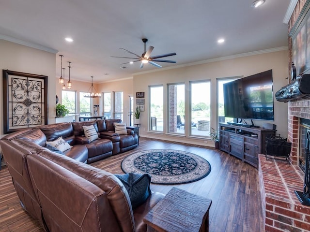 living room featuring a brick fireplace, an inviting chandelier, dark hardwood / wood-style floors, and ornamental molding