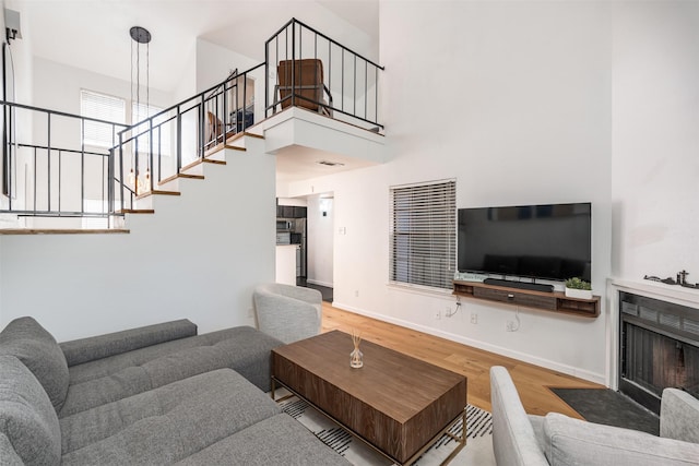 living room featuring hardwood / wood-style flooring and a towering ceiling