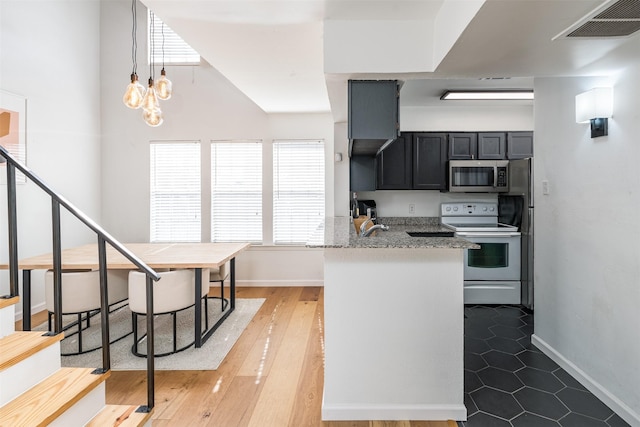 kitchen featuring pendant lighting, light stone counters, wood-type flooring, kitchen peninsula, and electric stove