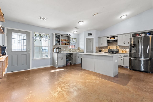 kitchen with gray cabinetry, backsplash, a kitchen island, stainless steel fridge with ice dispenser, and concrete floors