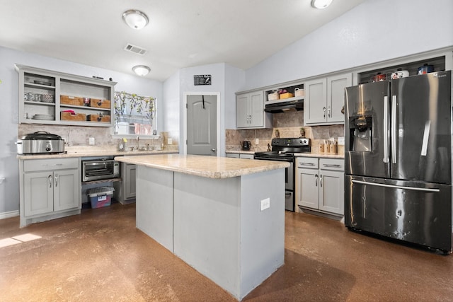 kitchen with lofted ceiling, gray cabinetry, stainless steel appliances, a center island, and decorative backsplash