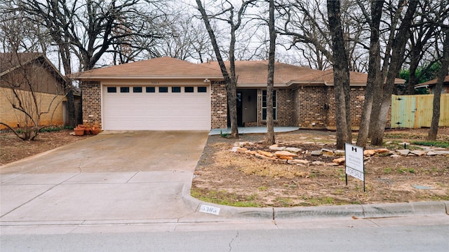 ranch-style home with a garage, brick siding, and driveway