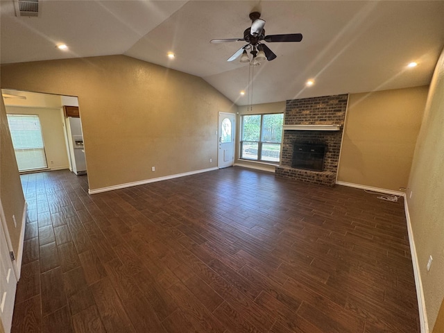 unfurnished living room featuring dark wood-style flooring, lofted ceiling, visible vents, a brick fireplace, and ceiling fan