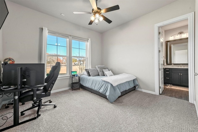 bedroom with carpet flooring, ceiling fan, ensuite bath, and baseboards