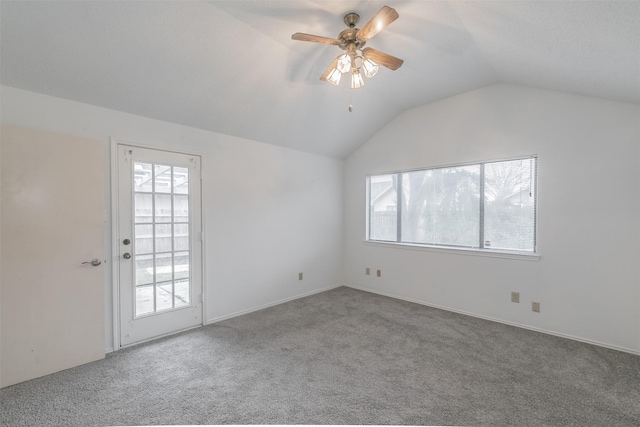 empty room with vaulted ceiling, carpet floors, and ceiling fan