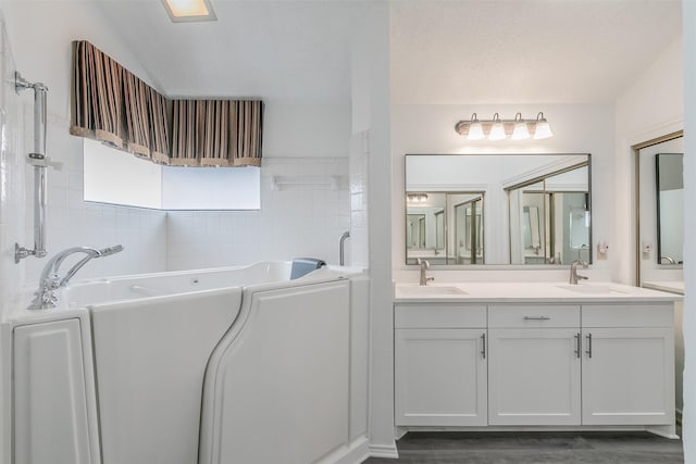 bathroom featuring a bathing tub, hardwood / wood-style floors, and vanity