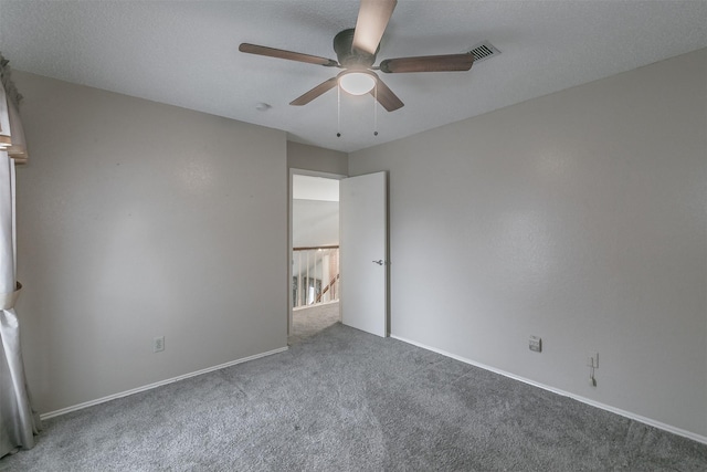 carpeted empty room featuring a textured ceiling and ceiling fan