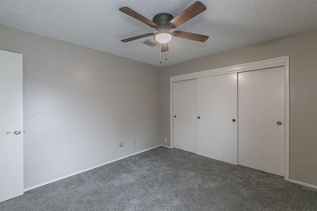 unfurnished bedroom featuring ceiling fan, a closet, dark carpet, and a textured ceiling