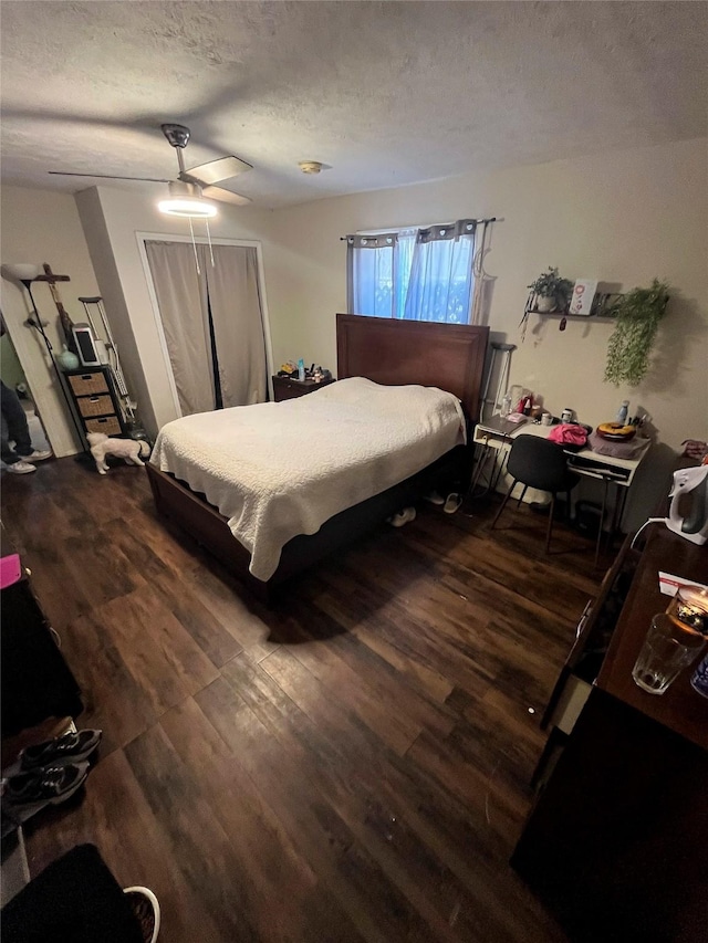 bedroom featuring ceiling fan, wood finished floors, and a textured ceiling