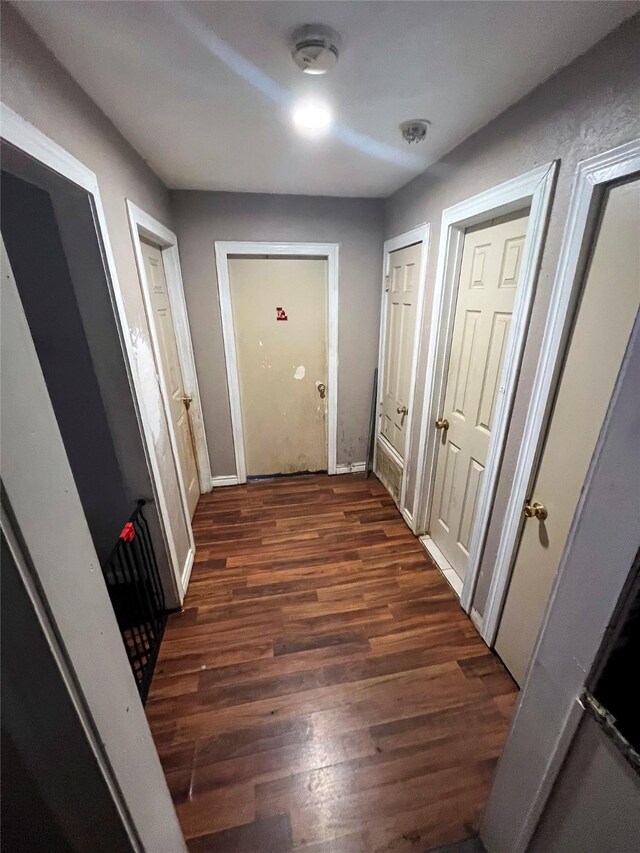 corridor with dark wood-style floors and baseboards