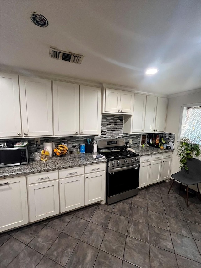 kitchen with decorative backsplash, visible vents, white cabinetry, and stainless steel appliances