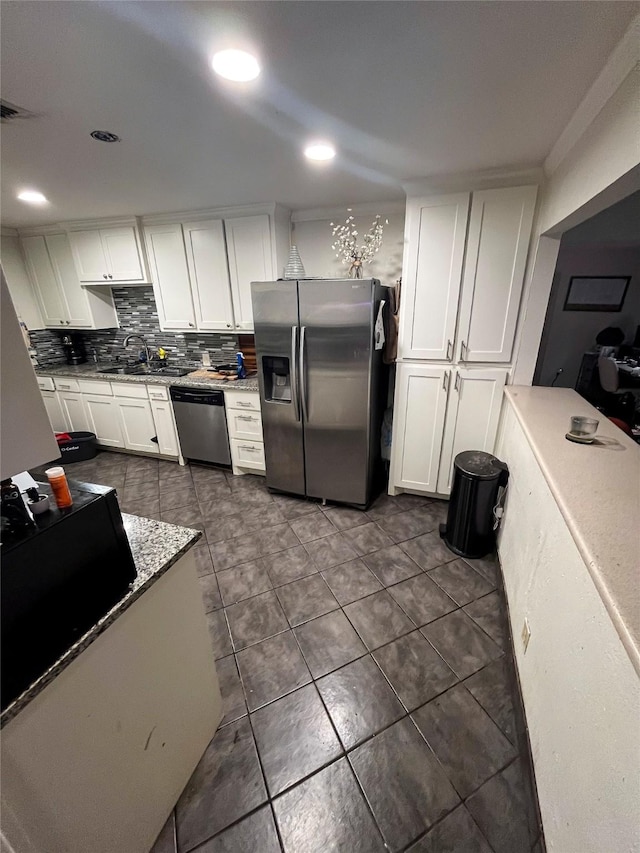 kitchen featuring a sink, stainless steel appliances, backsplash, and white cabinets