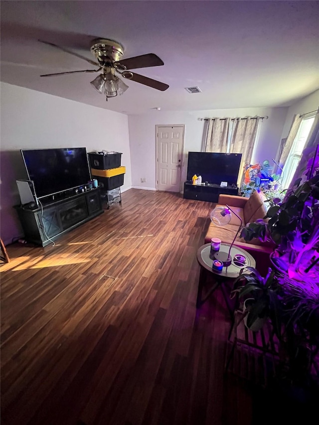 living area with a ceiling fan and wood finished floors