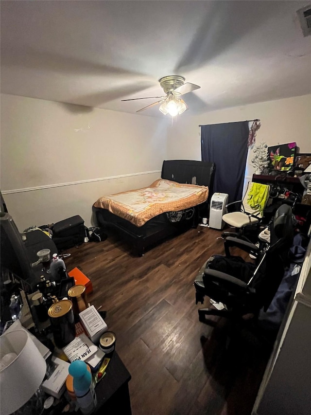 bedroom with wood finished floors, visible vents, and ceiling fan