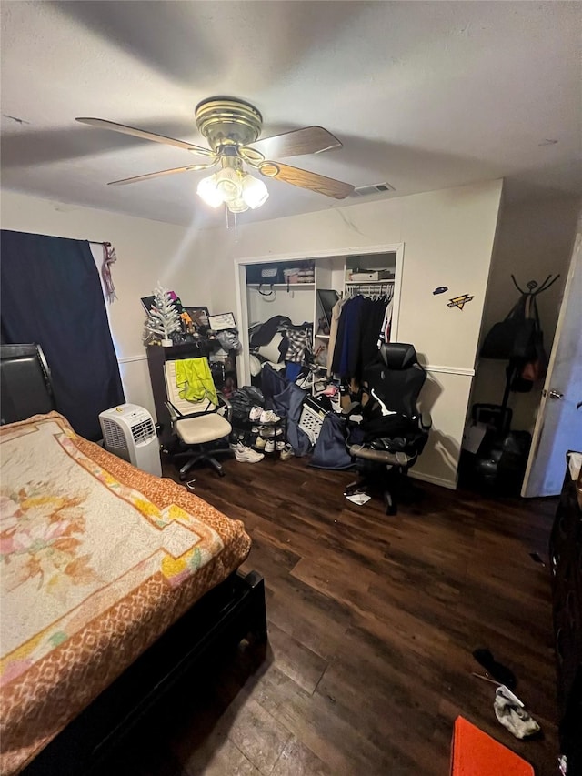 bedroom with a ceiling fan, wood finished floors, and visible vents