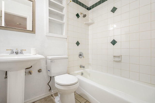 bathroom with tiled shower / bath, tile patterned floors, and toilet