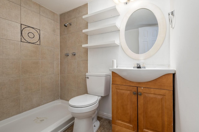 bathroom with vanity, toilet, and a tile shower