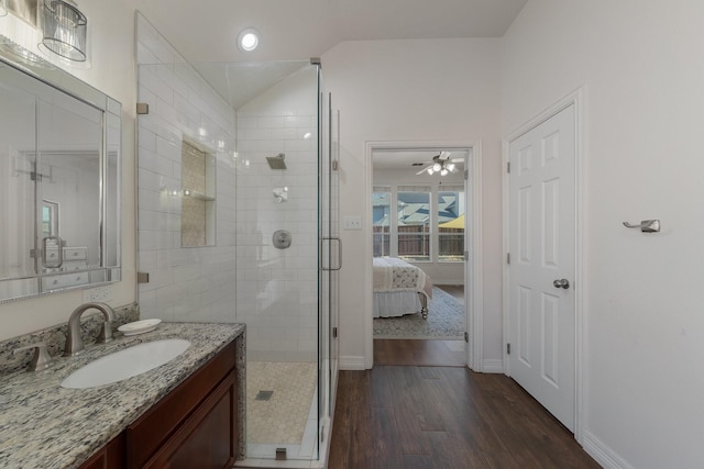 bathroom with an enclosed shower, vaulted ceiling, hardwood / wood-style floors, and vanity