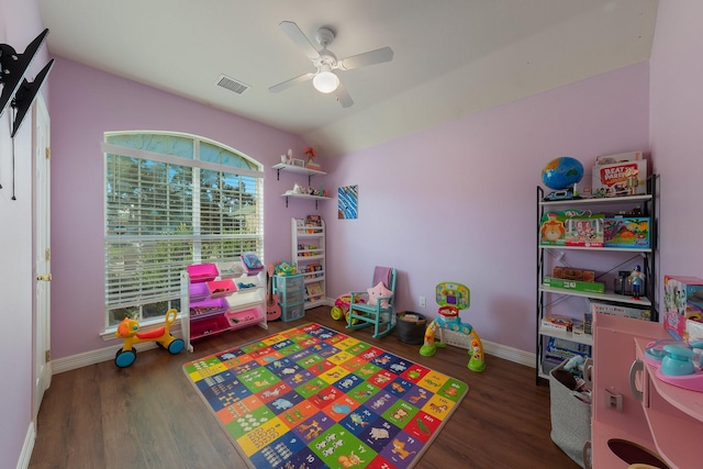 playroom with dark hardwood / wood-style flooring, vaulted ceiling, and ceiling fan