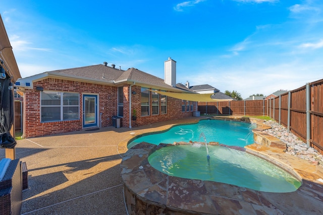 view of swimming pool featuring a patio, pool water feature, and an in ground hot tub