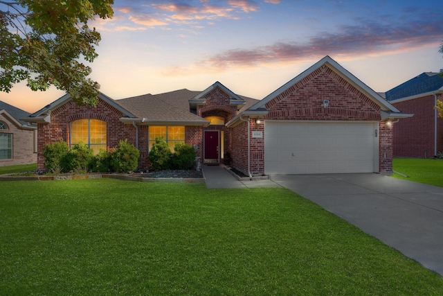 ranch-style house featuring a garage and a yard