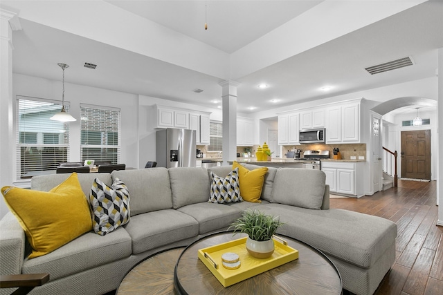 living room with wood-type flooring and decorative columns