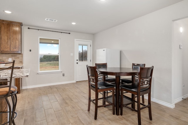 dining room with baseboards, visible vents, and light wood-style floors