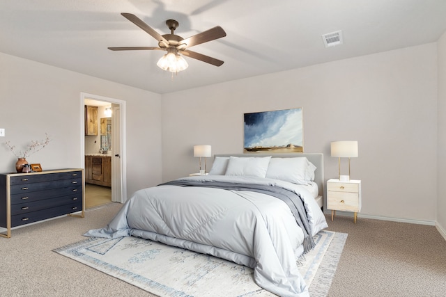 carpeted bedroom with ceiling fan and ensuite bath