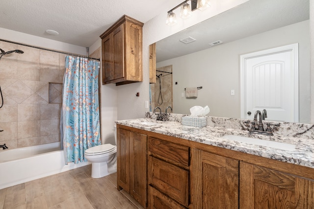 full bath featuring toilet, a textured ceiling, a sink, and shower / bath combo with shower curtain