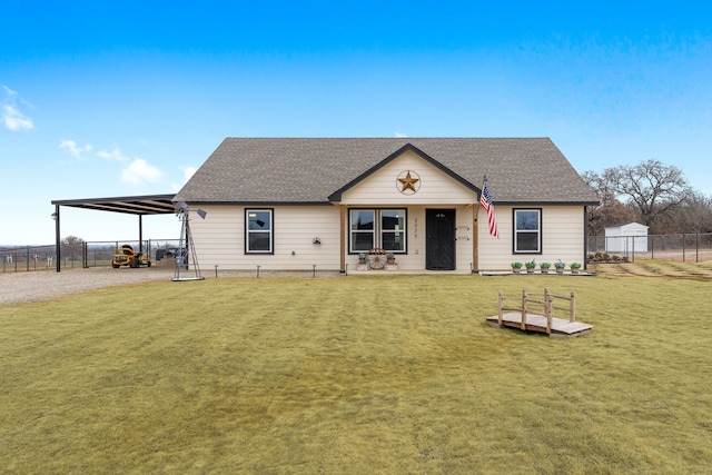 view of front of property with a carport, roof with shingles, a front yard, and fence