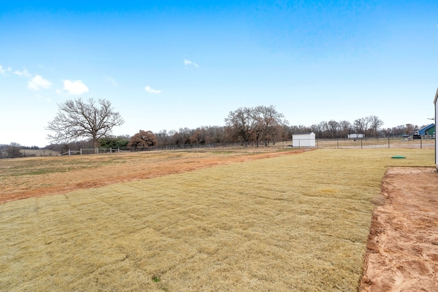 view of yard with fence and a rural view