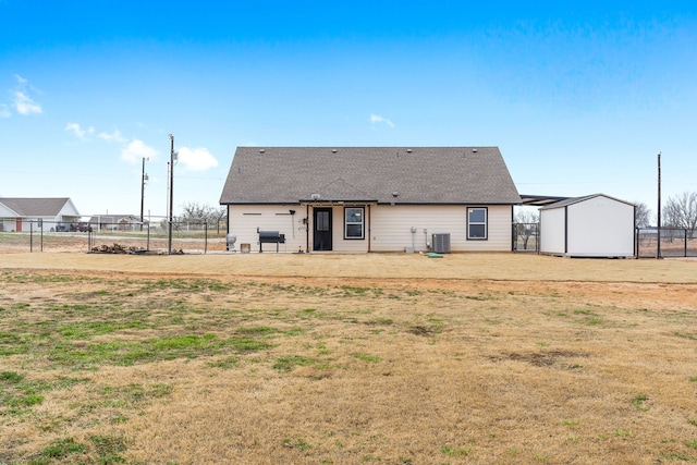 back of property with cooling unit, roof with shingles, and fence