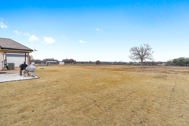 view of yard with a rural view and central AC unit