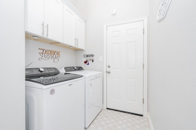 washroom featuring cabinets and washing machine and clothes dryer