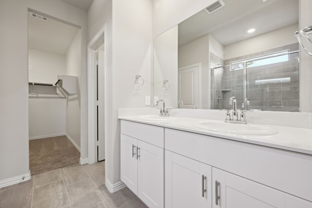 bathroom featuring tile patterned floors, vanity, and a shower with shower door