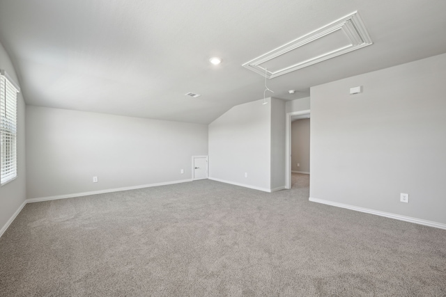 carpeted empty room with lofted ceiling