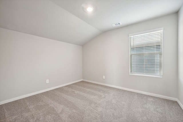 additional living space featuring vaulted ceiling and carpet flooring