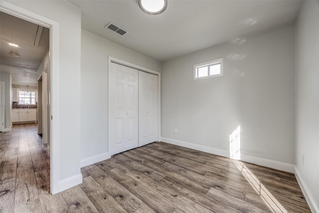 unfurnished bedroom featuring sink, hardwood / wood-style floors, and a closet