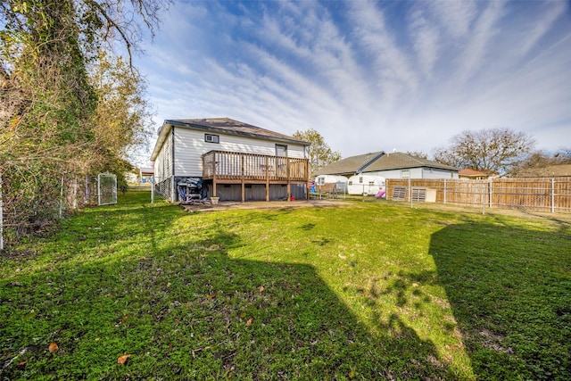 back of property featuring a wooden deck and a lawn