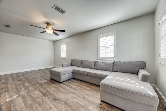 living room featuring light hardwood / wood-style floors and ceiling fan