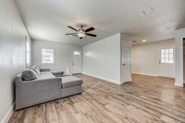 living room with ceiling fan and light wood-type flooring