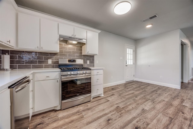 kitchen featuring backsplash, appliances with stainless steel finishes, light hardwood / wood-style flooring, and white cabinets