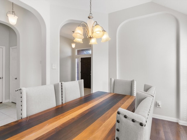 dining space with dark hardwood / wood-style flooring and a chandelier