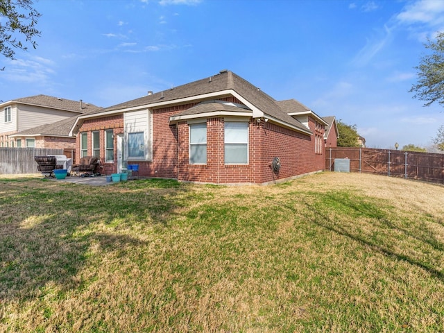 rear view of house featuring a patio and a yard