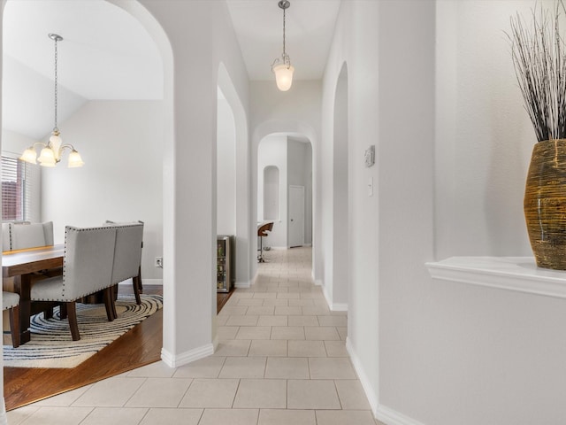 hall with lofted ceiling and light tile patterned floors