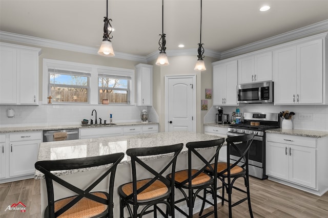 kitchen featuring white cabinetry, appliances with stainless steel finishes, and decorative light fixtures