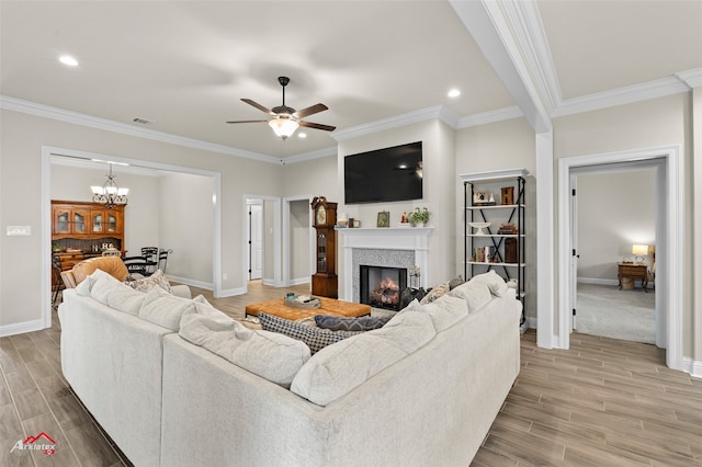 living room with crown molding, ceiling fan with notable chandelier, and hardwood / wood-style floors