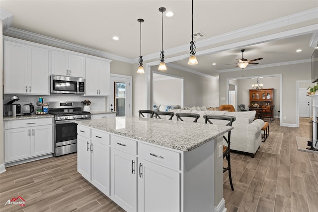 kitchen with white cabinetry, appliances with stainless steel finishes, and a kitchen breakfast bar